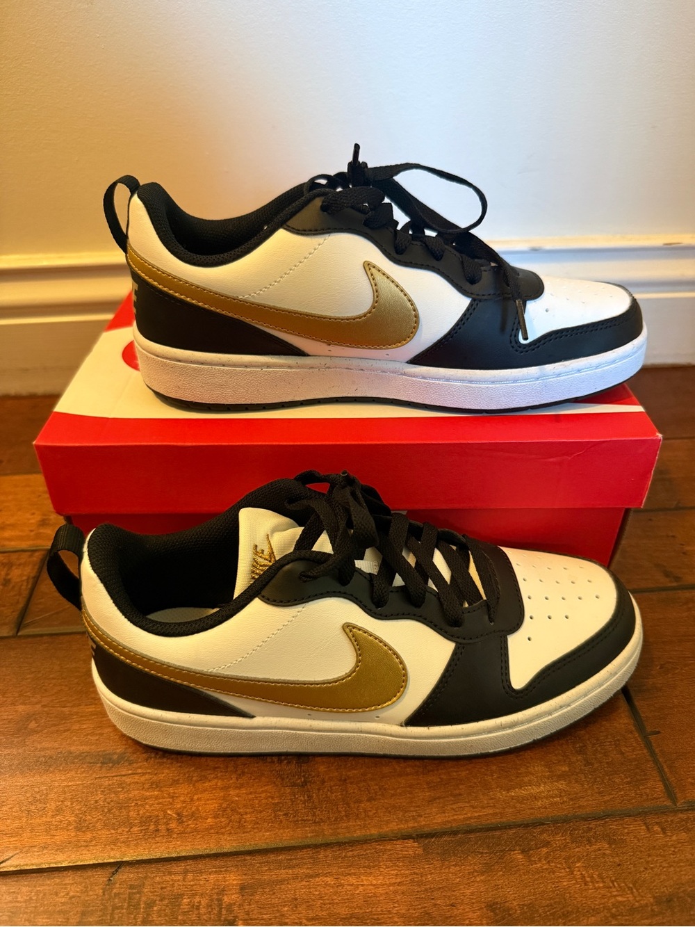 Nike Low-Top Sneakers in White, Black & Gold Swoosh